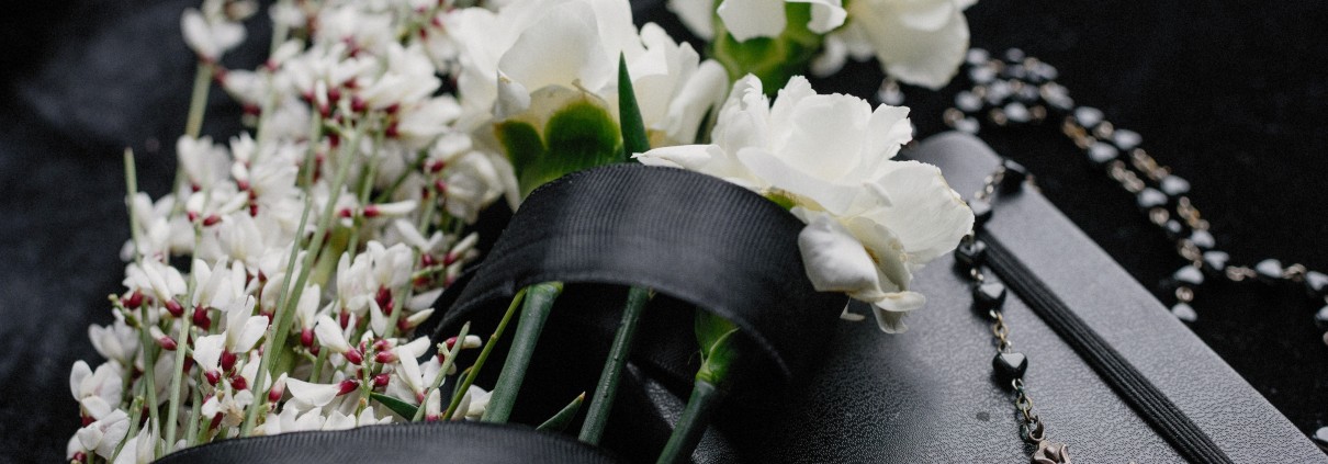 Foto di Ksenia Chernaya: https://www.pexels.com/it-it/foto/fiori-cerimonia-libro-funerale-8986709/