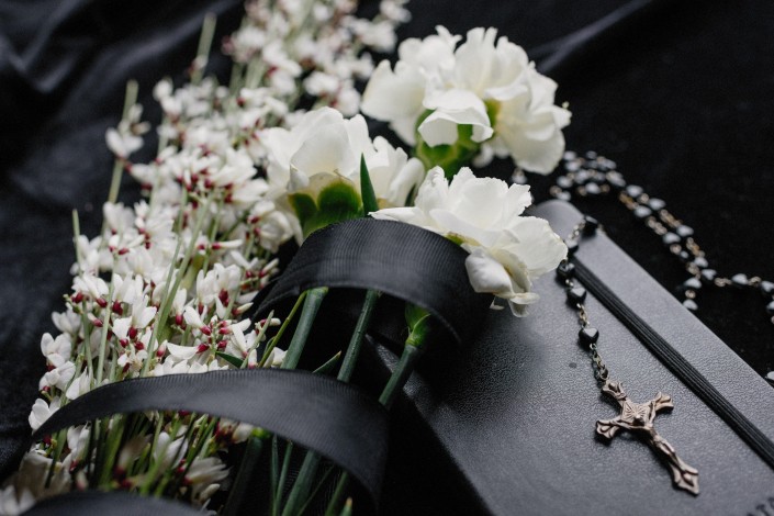 Foto di Ksenia Chernaya: https://www.pexels.com/it-it/foto/fiori-cerimonia-libro-funerale-8986709/