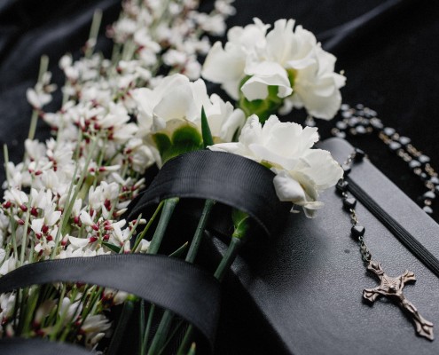 Foto di Ksenia Chernaya: https://www.pexels.com/it-it/foto/fiori-cerimonia-libro-funerale-8986709/